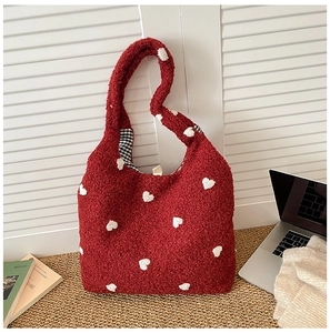 Detail of red plush tote bag with white hearts and black check pattern lining