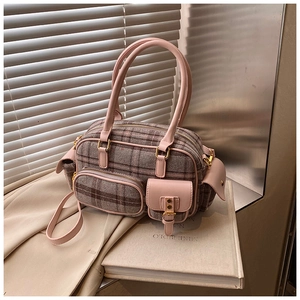 Détail du sac bowling en cuir rose et tissu à carreaux avec fermetures éclair dorées