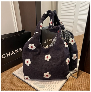 Detail of navy knit tote bag featuring white floral 3D patterns and checkered lining