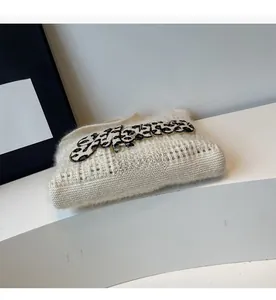 Close-up of fluffy white knitted fabric featuring a leopard print letter embroidery