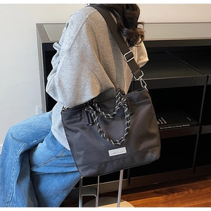 Détail du sac cabas oxford noir avec poignées en corde tissée et bandoulière en nylon