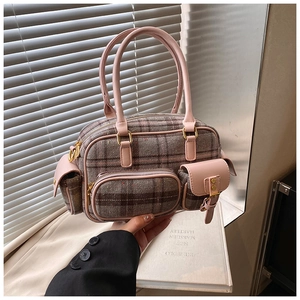 Détail du sac bowling à carreaux vintage avec anses en cuir rose et poches multiples