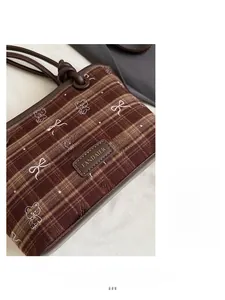 Gros plan du sac vintage à carreaux marron avec broderie d'ours et patch en cuir chic