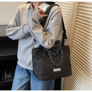 Détail du sac cabas en tissu Oxford noir avec poignées tressées et bandoulière réglable