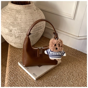 Détail du sac hobo marron vintage avec breloque ours et fermeture éclair élégante