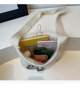 Spacious interior of beige knitted tote bag showing capacity for books and phone