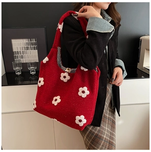 Detail of red wool tote bag with white flower patches and stylish wooden button closure