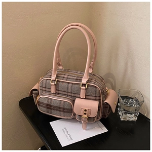 Détail des coutures en cuir rose et tissu à carreaux sur un sac à main rétro bowling