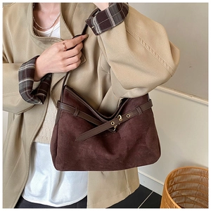 Detailed view of dark brown suede tote bag with leather strap and golden hardware
