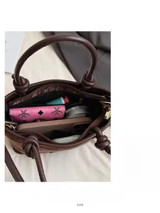 Détail d'un sac cabas en cuir marron montrant sa grande capacité et ses rangements