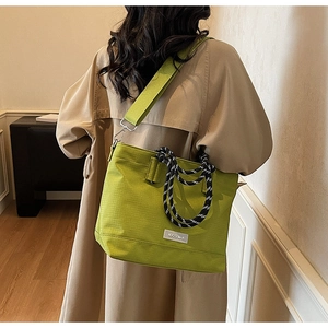 Sac fourre-tout vert en oxford avec poignées tressées et bandoulière sur le modèle