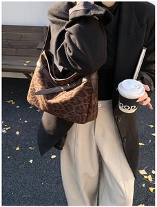 Detail of leopard print suede hobo bag with leather trim and adjustable gold buckle