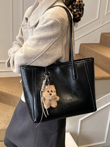 Minimalist black PU leather tote bag with long straps and a cute plush bear charm