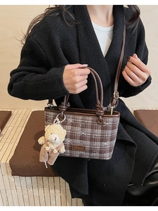 Détail du sac seau à carreaux marron avec imprimés ours et un joli pendentif ours en peluche
