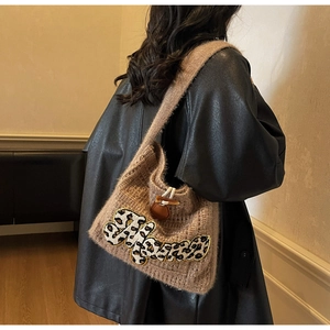 Detail of a brown knit shoulder bag with leopard print letter patch and leather buckle
