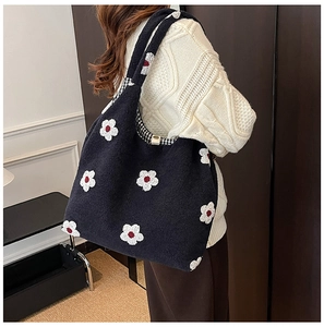 Detailed close-up of blue plush tote bag with white flower embroidery and checkered lining