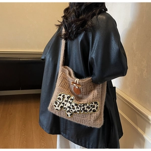 Close-up of brown knit tote bag featuring leopard Mama patch and horn buckle detail