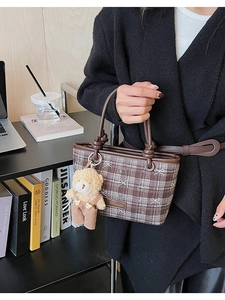 Chic brown plaid bucket bag with cute bear pendant in a lifestyle commuting scene