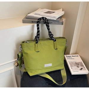 Détail du cabas en tissu oxford vert avocat avec poignée tressée et texture quadrillée