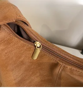 Dettaglio della cerniera dorata sulla borsa tote in pelle marrone martellata