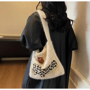 Detail of cream plush tote bag featuring leopard print letter patch and dark leather charm