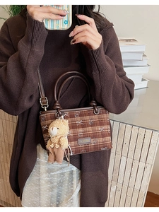 Brown checkered bucket bag with cute bear pattern and plush keychain on a casual outfit