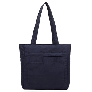 Detail of a navy blue waterproof nylon tote bag with front pocket and durable stitching