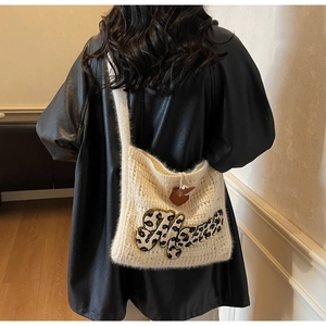 Detail of cream knit shoulder bag with leopard print 'Home' embroidery and horn button