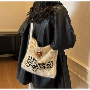 Close-up of knit tote bag featuring a leopard print patch and toggle horn button detail