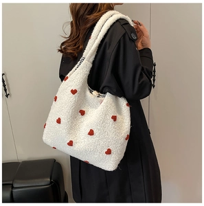 Detailed close-up of white plush tote bag featuring red heart patterns and gingham lining