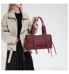Detail of burgundy gothic tote bag featuring decorative fringe and lace-up textures