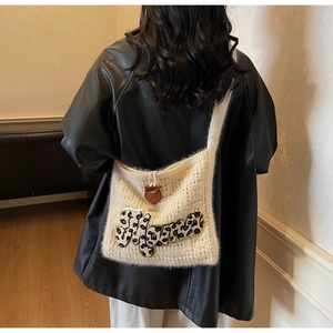 Detail of cream knit crossbody bag with leopard print embroidery and leather horn button