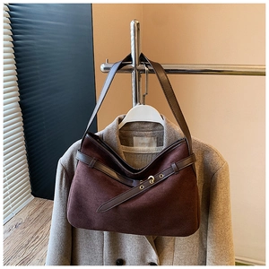 Detailed close-up of dark brown suede shoulder bag with vintage gold buckle hardware