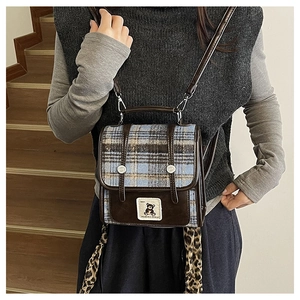 Détail du sac cabas à carreaux avec lanières en cuir marron et rubans léopard élégants