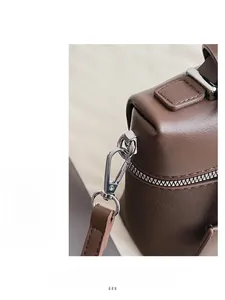 Detail of high-quality silver metal hooks and zipper on a brown leather shoulder bag