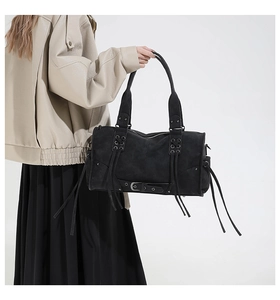 Detail of vintage gothic black leather tote bag with lace-up straps and buckle accents