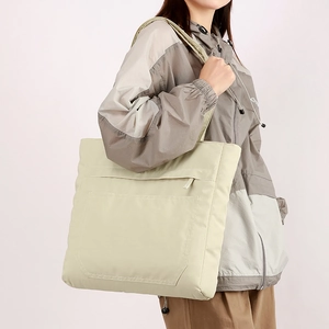 Detailed side view of a large capacity waterproof nylon tote bag worn by a model
