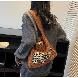 Detailed back view of a brown knit tote bag with leopard print letter M and horn button closure