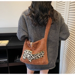 Close-up of brown knit tote bag featuring Mama leopard patch and horn buckle closure