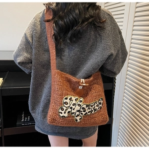Detail of knitted shoulder bag featuring leopard print Mama patch and wooden toggle closure