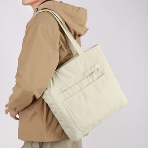 Detail view of large nylon tote bag featuring front zipper pockets and spacious design