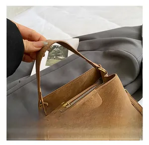 Vue détaillée du sac seau marron en cuir texturé avec fermeture éclair et perles décor
