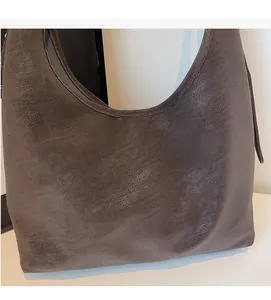Close-up of the soft textured dark brown faux leather and slouchy shape of the tote bag