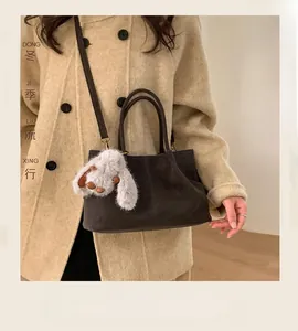 Detail of dark brown faux suede tote bag with a cute long-eared bunny plush charm