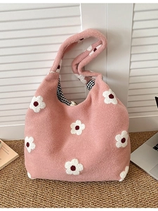 Pink plush tote bag with flower patterns and checkered lining on straw carpet