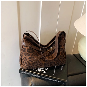 Detail of leopard print hobo bag with gold hardware buckles and brown shoulder strap