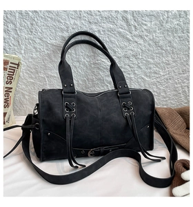 Detailed view of punk style tote bag with silver zippers, rivets and crossbody strap