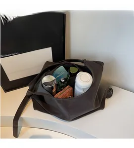 Interior view of spacious dark brown leather tote bag with daily items and storage detail