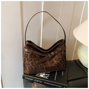 Close-up of leopard print suede hobo bag with brown leather strap and gold buckle