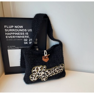 Detail of black knit tote bag with leopard Mama patch and vintage horn button closure